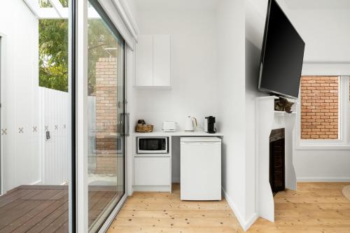 a kitchen with white appliances and a sliding glass door at Eastern Beach Retreat in Geelong