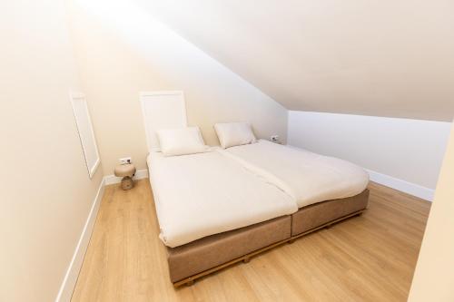 a small bedroom with a bed in a attic at VlieMare Appartementen De Kluut in Oost-Vlieland