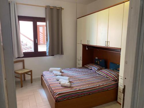 Un dormitorio con una cama con toallas. en Le Rose Marine, en Isola Rossa