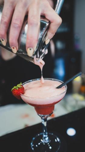 a person is pouring a strawberry into a cocktail at Hotel Le Perigord in La Roque-Gageac