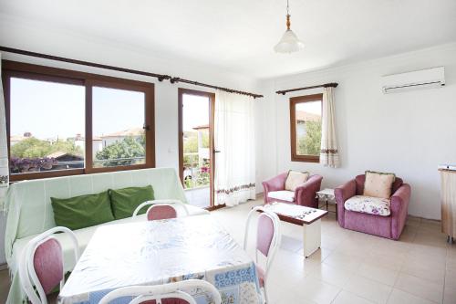 a living room with a table and chairs at Flat w Nature View Balcony 1 min to Beach in Datca in Datca