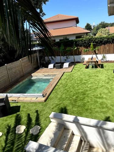 a backyard with a swimming pool and a house at Logement avec piscine privée chauffée in Biarritz