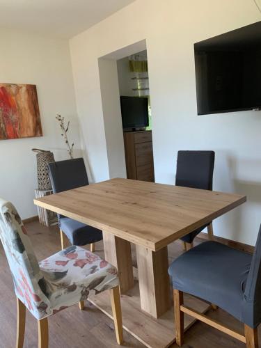 a wooden dining room table with chairs and a television at Ferienwohnung KaRo in Bodensdorf
