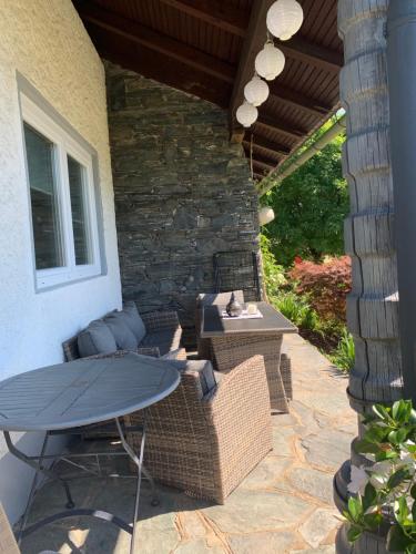 a patio with a table and chairs and a stone wall at Ferienwohnung KaRo in Bodensdorf