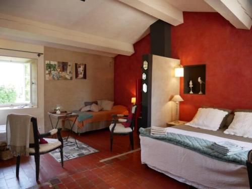 a bedroom with red walls and a bed and a desk at La maison de Muriel in Rustrel