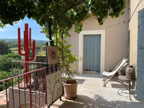 a balcony with a gate and a chair and a door at La maison de Muriel in Rustrel