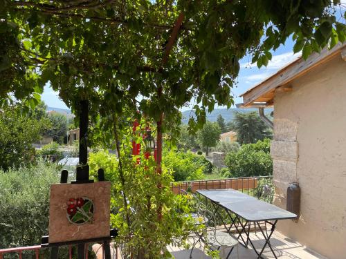 a picnic table on the balcony of a house at La maison de Muriel in Rustrel