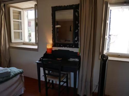 a bedroom with a desk with a mirror and a bed at La maison de Muriel in Rustrel