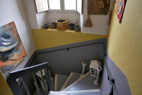 a room with a staircase with a window and boxes at La maison de Muriel in Rustrel