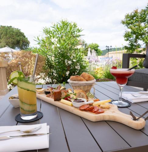 a table with a tray of food and a drink at Hotel Le Perigord in La Roque-Gageac