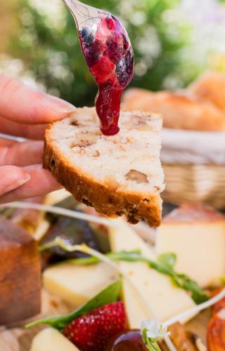 a spoon holding a piece of bread with jam on it at Hotel Le Perigord in La Roque-Gageac