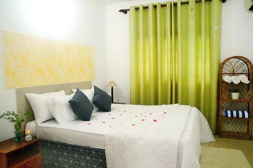 a bedroom with a bed with red flowers on it at Calm Villa Wadduwa in Wadduwa