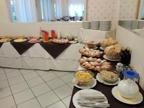 stół z wieloma talerzami jedzenia w obiekcie Hotel Villa Mon Reve w Rimini