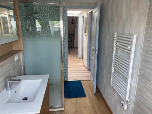 a bathroom with a sink and a door to a hallway at La maison Mousseaux, Centre ville 2 chambres in Châteauroux