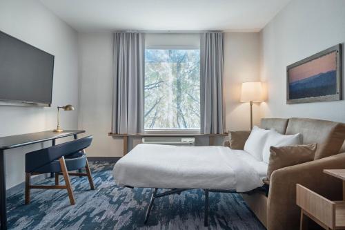 ein Hotelzimmer mit einem Bett, einem Sofa und einem Fenster in der Unterkunft Fairfield Inn & Suites by Marriott Penticton in Penticton