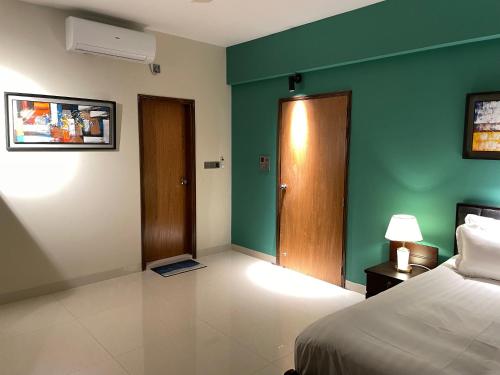 a bedroom with a bed and a green wall at CityLights - Mayfair Signature Collection Gulshan in Dhaka
