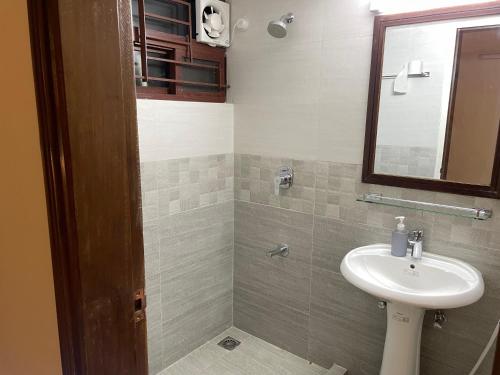 a bathroom with a sink and a mirror at Gulshan Stylish 3 bedroom Luxury Apartment in Prime location in Dhaka