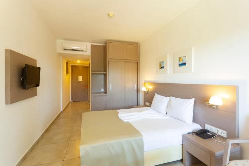a hotel room with a bed and a television at Bodrum Seaside Beach Club in Bodrum City