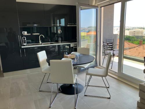 eine Küche und ein Esszimmer mit Tisch und Stühlen in der Unterkunft Apartment Welcome in Trogir