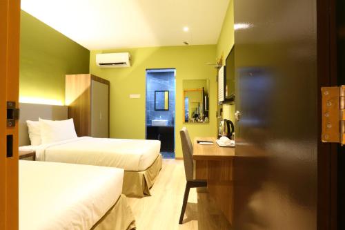 a hotel room with two beds and a desk at YEE HOTEL Permas Jaya in Johor Bahru