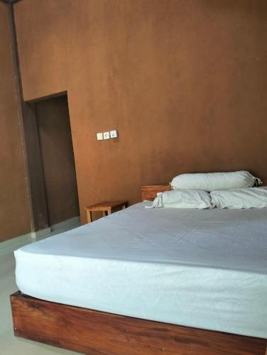 a bedroom with a large bed with white sheets and pillows at Fullmoon homestay in Kuta Lombok