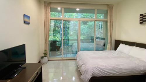 1 dormitorio con cama y ventana grande en Mountain Lodge, en Taimali