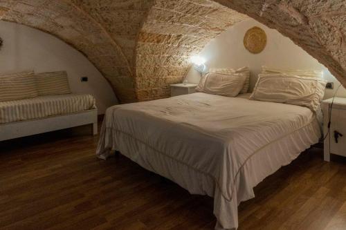 アッリステにあるZen Guest House Olisticaの石壁のベッドルーム1室(大型ベッド1台付)