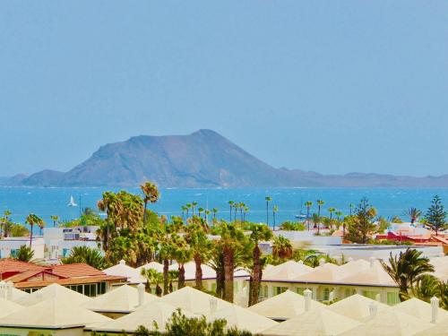 a view of a resort with palm trees and the ocean at El Mirador de Lobos Fuerteventura in Corralejo