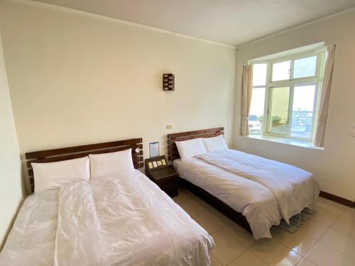 a bedroom with two beds and a window at Mountain Lodge in Taimali