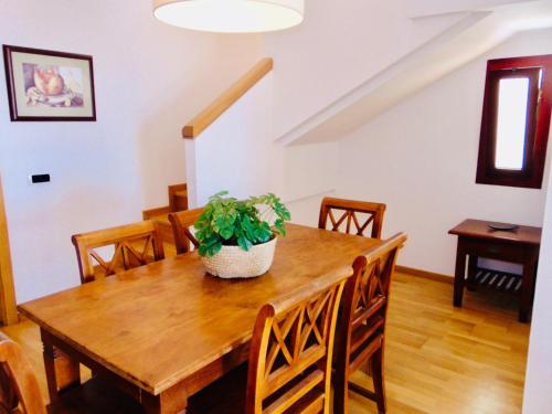 - une salle à manger avec une table en bois et une plante en pot dans l'établissement El Mirador de Lobos Fuerteventura, à Corralejo