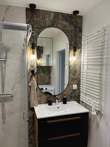 a bathroom with a sink and a mirror at Apartament 30 in Płock
