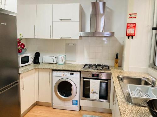 a kitchen with a washing machine and a sink at Downtown Apartment in Horta