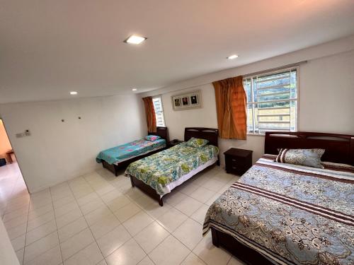 1 Schlafzimmer mit 2 Betten und einem Fenster in der Unterkunft Terbilang Homestay in Butterworth
