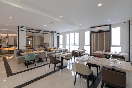 a restaurant with tables and chairs and a couch at Kantary Hotel Banchang in Ban Chang
