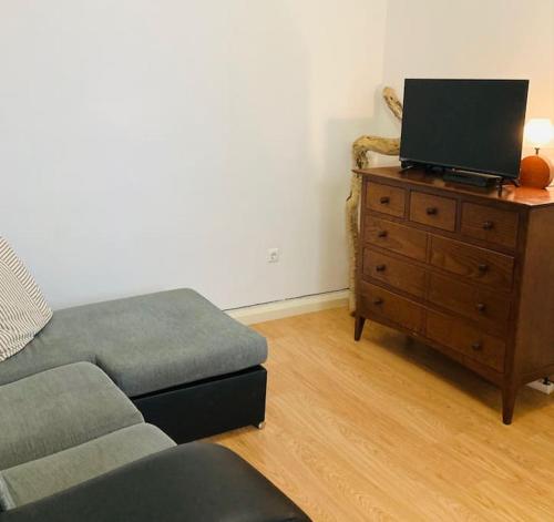 a living room with a couch and a tv on a dresser at Downtown Apartment in Horta
