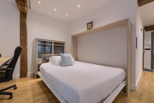 1 dormitorio con 1 cama blanca grande y 1 silla en Moderno y Lujoso en el Historico Casco Viejo, en Bilbao