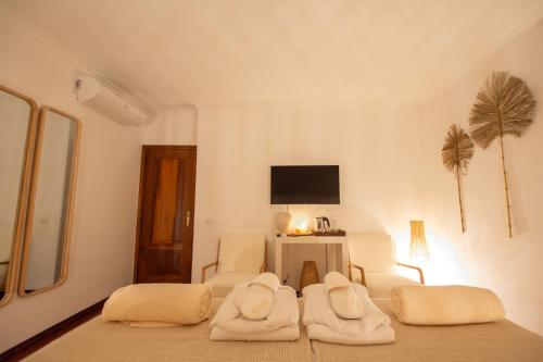 a white room with two white chairs and a television at Villa Pietra Estoril Eco Guesthouse in Estoril