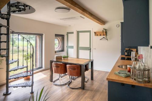 uma cozinha com mesa e cadeiras num quarto em Het Heerengoedt em Ambt Delden