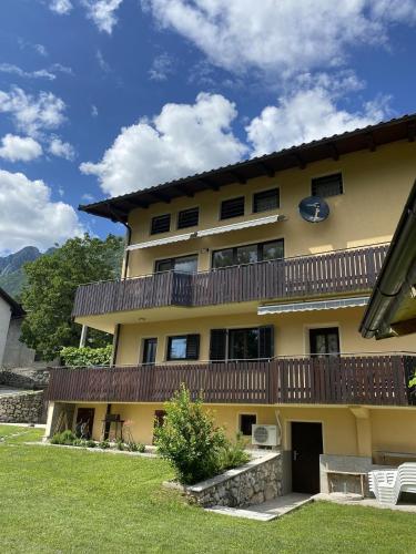 a large yellow building with a balcony at Apartma Logar in Kobarid