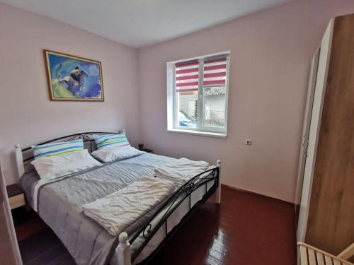 1 dormitorio con cama y ventana en Mira Home en Veliko Tŭrnovo