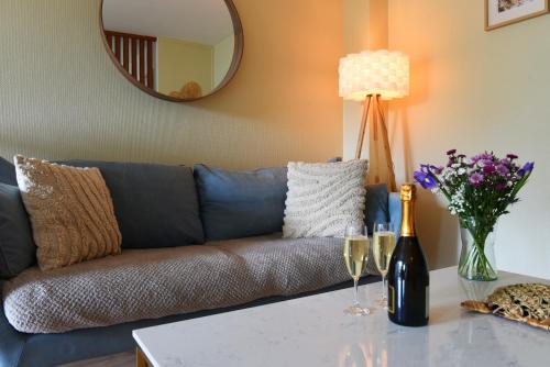 sala de estar con sofá y mesa con copas de vino en Les rives de l’Indre. Parking gratuit. Lit 160CM, en Châteauroux