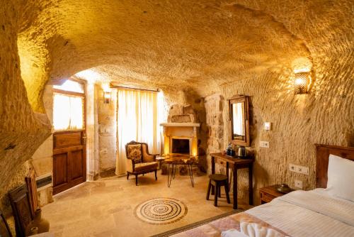 a bedroom with a bed and a table and a chair at Atilla's Cave Hotel in Nevsehir