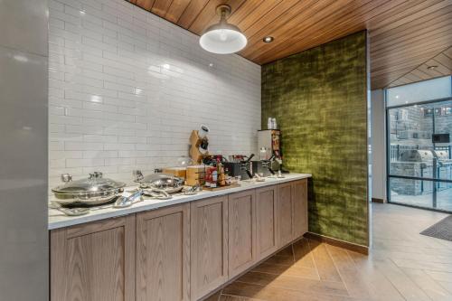 a kitchen with wooden cabinets and a green wall at Fairfield by Marriott Inn & Suites North Conway in North Conway