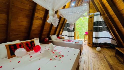 um quarto com duas camas e balões no chão em Habarana Tree House Ambasewana Resort em Habarana