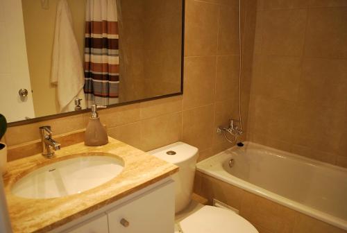 a bathroom with a sink and a toilet and a tub at Apartamento El Yodo in Antofagasta