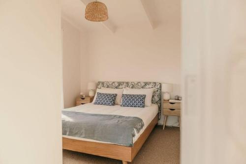 ein Schlafzimmer mit einem Bett mit blauen und weißen Kissen in der Unterkunft Saltair Freycinet in Dolphin Sands