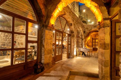 an arched hallway with a stone building with windows at Atilla's Cave Hotel in Nevsehir
