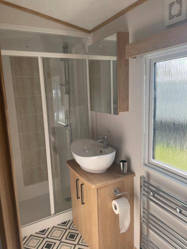 a bathroom with a sink and a shower at Summer’s Lodge in Swarland