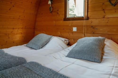 1 dormitorio con 2 camas en una cabaña de madera en Buitengewoon Overnachten, en Terheijden