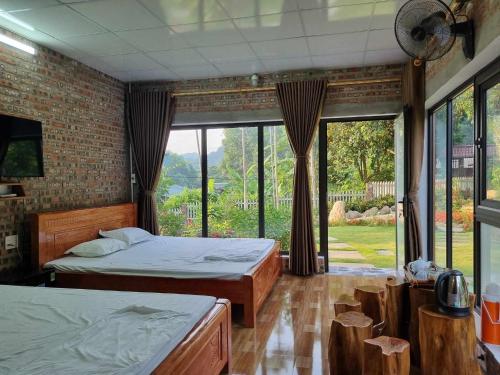 a bedroom with two beds and a large window at Trường Anh Homestay Hà Giang in Ha Giang